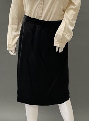 an image of a mannequin wearing a black skirt and a beige shirt