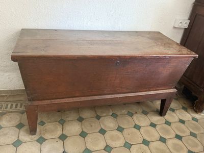 an old wooden chest sitting on top of a tiled floor