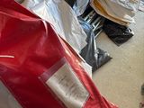 un parapluie rouge et blanc posé par terre à côté d'un immeuble