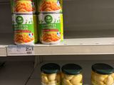 several jars of pickles sit on a shelf in a grocery store