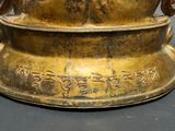 a gold vase with writing on it sitting on a table