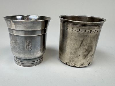 deux tasses en argent posées l'une à côté de l'autre sur une table