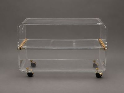 un chariot de bar en acrylique transparent et en laiton, équipé de roulettes
