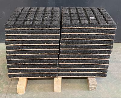 a stack of black bricks sitting on top of a wooden pallet
