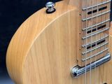 a close up of a wooden guitar with a black background