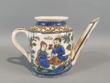blue and white teapot with a design of a man and a woman
