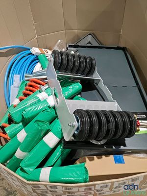 une boîte contenant plusieurs tuyaux verts et une paire de ciseaux