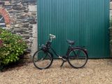 a black bicycle parked in front of a green door