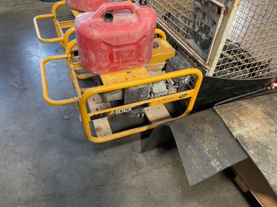 deux bidons d'essence rouges posés sur un chariot dans un entrepôt