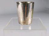 une coupe en argent posée sur un socle transparent