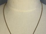a gold necklace with a bar pendant on a mannequin neck
