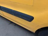 a close up of a yellow car parked on the side of the road