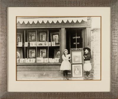 a black and white photo of a woman and a child in front of a book store