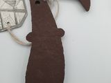 a brown ornament hanging from a string on a white table