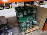 de nombreux pots de peinture posés sur des palettes dans un entrepôt