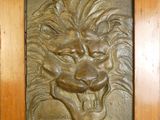 un gros plan sur une plaque représentant un lion, fixée au mur