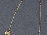 un gros plan d'un collier en or sur un fond bleu
