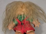 a small doll with blonde hair and a red dress