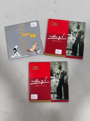 three books on a white table with a dog and a cat