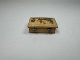 an old wooden box with a painting on it sitting on a white surface