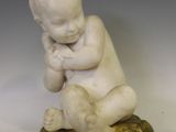 une petite statue représentant un bébé assis sur le dos d'une tortue