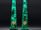 a pair of green marble obelisks with gold accents