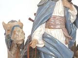 a figurine of a man riding a camel next to a statue of a man