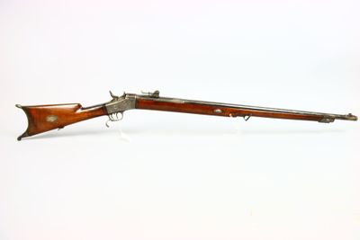 un vieux fusil avec un canon en bois et une poignée en bois