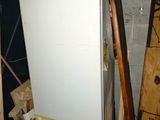 a white refrigerator in the middle of a pile of wood