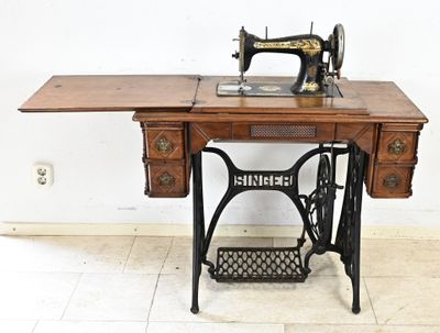 une machine à coudre posée sur une table en bois