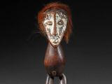 a close up of a wooden sculpture of a person with red hair