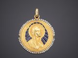 a gold and pearl pendant with an image of jesus