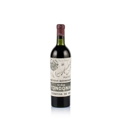 the bottle of wine is sitting on a white surface