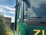 a green truck that is parked on the side of the road