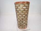 un vase posé sur un support sur une surface blanche