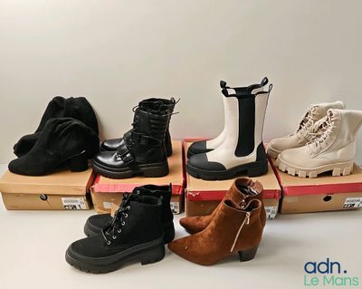 several pairs of women ' s boots sitting on top of boxes