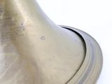 a brass bell on a white surface with a white background