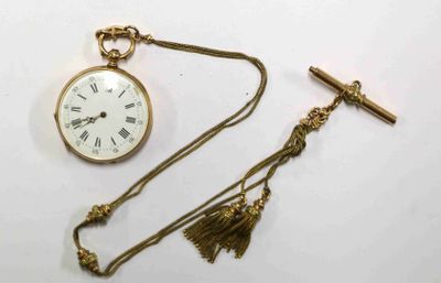 une montre de poche en or et une croix posées sur une table blanche