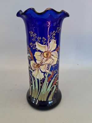 a blue vase with flowers on it sitting on a table