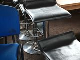a lot of stools that are sitting in front of a table