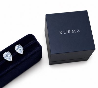 un gros plan sur une paire de boucles d'oreilles en diamant dans un écrin noir