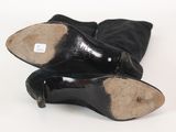 pair of black leather boots on a white background with a label on the heel