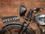 a old motorcycle that is parked in front of a brick wall