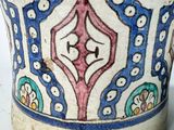 a close up of a vase on a white surface