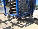 a blue trailer with a bunch of metal bars on it