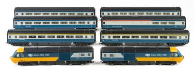 four trains sitting next to each other on a white surface