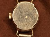 an image of a close up of a watch on a brown cloth