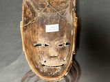 an image of a wooden mask with long hair on a table