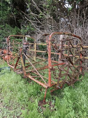 un engin agricole rouillé abandonné dans l'herbe