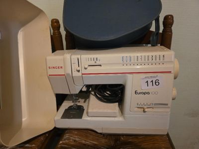 une machine à coudre posée sur une chaise en bois